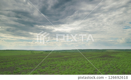 A Vast and Expansive Green Landscape Spreads Out Beneath a Dramatic, Cloudy Sky Above It Time lapse. 126692618