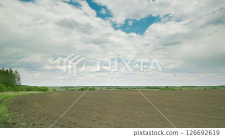 A Broad and Expansive Agricultural Landscape Beneath Dramatic, Captivating Skies Above Time lapse. A Broad and Expansive Agricultural Landscape Beneath Dramatic, Captivating Skies Above Time lapse. 126692619
