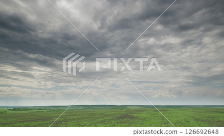 A Vast and Expansive Green Landscape Beautifully Set Under Dramatic and Moody Clouds Above Time lapse. 126692648