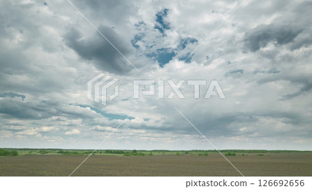 An Expansive Open Field Spreading Under a Dramatic and Cloudy Sky Displaying Natures Beauty Time lapse. An Expansive Open Field Spreading Under a Dramatic and Cloudy Sky Displaying Natures Beauty Time lapse. 126692656