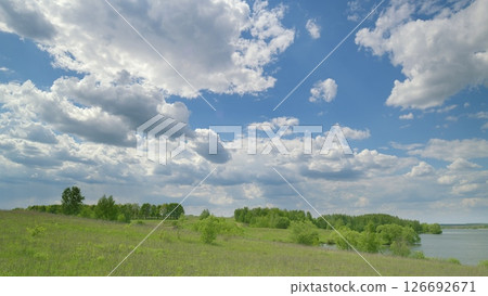 A Serene Nature Landscape Featuring Lush Greenery Surrounded by a Cloudy Sky Above Time lapse. 126692671