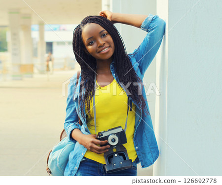 Summer portrait of happy smiling young woman photographer with film camera wearing summer straw hat Summer portrait of happy smiling young woman photographer with film camera wearing summer straw hat 126692778