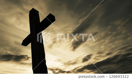 A massive lumber beam stands vertically, creating a striking silhouette against a dramatic sky. 126693322