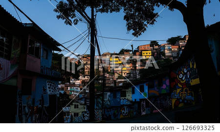 A silhouette of a quaint, artsy neighborhood with colorful murals comes alive in the golden evening light. 126693325