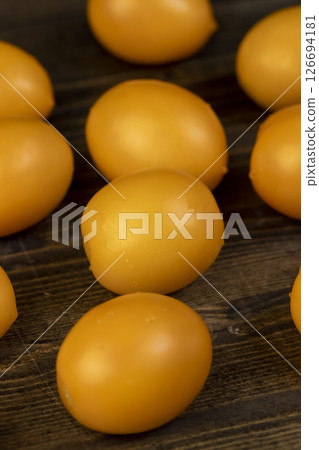 wet tomatoes of small size with soft and juicy flesh, yellow tomatoes covered with drops of water 126694181