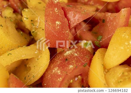 preparation of salad from sliced tomatoes with spices and oil, closeup preparation of salad from sliced tomatoes with spices and oil, closeup 126694182
