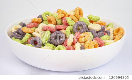 Bowl of colorful crispy corn rings on white background. Breakfast cereal Bowl of colorful crispy corn rings on white background. Breakfast cereal 126694805
