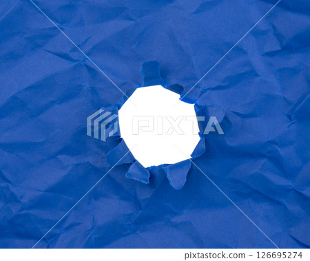 Paper hole with torn sides on a background. Through the paper. A ragged hole.An accurate shot. The concept of advertising and breakthrough. 126695274