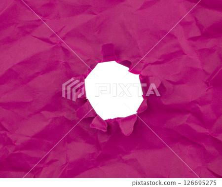 Paper hole with torn sides on a background. Through the paper. A ragged hole.An accurate shot. The concept of advertising and breakthrough. 126695275