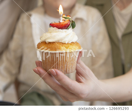 Birthday muffin with candle in hand selective focus Birthday muffin with candle in hand selective focus 126695293