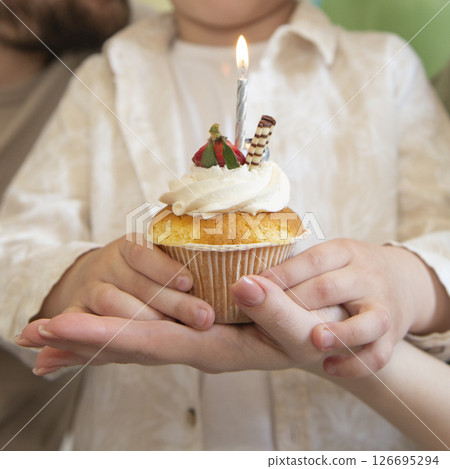 Birthday muffin with candle in hand selective focus Birthday muffin with candle in hand selective focus 126695294