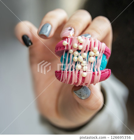 Female hands holding colorful french macaroons 126695356