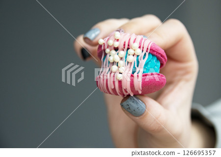Female hands holding colorful french macaroons 126695357