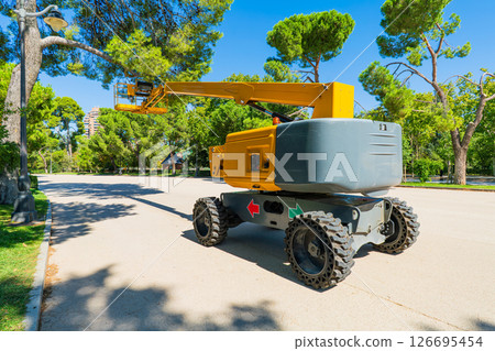 Mobile Boom Lift Platform in City Park on Sunny Day Mobile Boom Lift Platform in City Park on Sunny Day 126695454