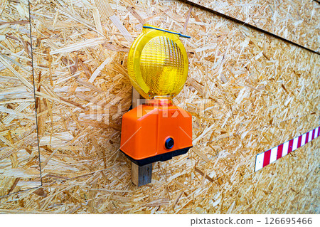 Construction Warning Light Mounted on OSB Panel with Barrier Stripe 126695466