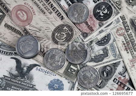 Greenback US paper dollars and silver certificates with silver dollar coins background 126695677