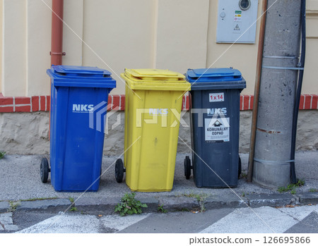Nitra, Slovakia - 05.21.2025: Various colored bins for collecting materials for recycling on city street. Nitra, Slovakia - 05.21.2025: Various colored bins for collecting materials for recycling on city street. 126695866