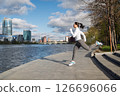 Sporty Woman Stretching Outdoors by the City Waterfront at Sunrise 126696066