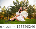 Beautiful Woman Posing in Nature at Sunset in White Dress 126696240