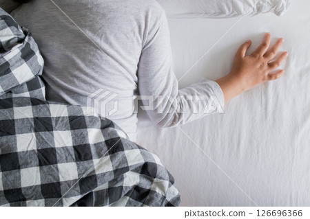 Young asian child sleeping comfortably in bed with checkered blanket Young asian child sleeping comfortably in bed with checkered blanket 126696366