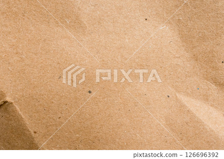 Close up of brown textured paper surface with subtle creases Close up of brown textured paper surface with subtle creases 126696392