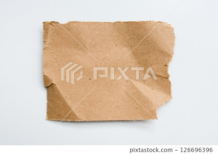 Brown torn paper on white background with textured surface and rough edges 126696396