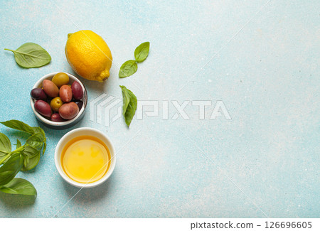 Fresh ingredients creating concept of cooking authentic italian cuisine meal, with lemon, olive oil, olives and basil top view, space for text Fresh ingredients creating concept of cooking authentic italian cuisine meal, with lemon, olive oil, olives and basil top view, space for text 126696605