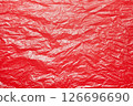 A textured red crumpled paper background with natural creases and folds. Ideal for design projects, digital graphics, or creative presentations requiring a vibrant 126696690