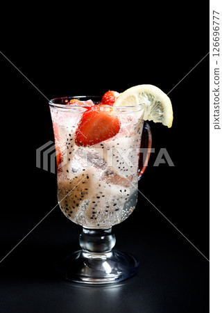 Refreshing cocktail with pitahaya and strawberries in an Irish coffee glass and garnished with a slice of lemon. Refreshing cocktail with pitahaya and strawberries in an Irish coffee glass and garnished with a slice of lemon. 126696777