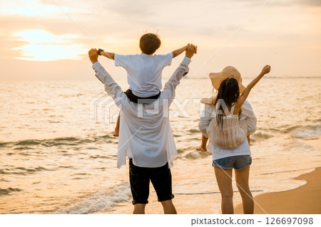 Happy family day. Parents carrying children on shoulders at the beach on sunset time, Father, Mother and kids playing together outdoors on summer beach, Family on holiday summer vacation travel Happy family day. Parents carrying children on shoulders at the beach on sunset time, Father, Mother and kids playing together outdoors on summer beach, Family on holiday summer vacation travel 126697098