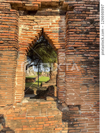 Historic remains of a Buddhist temple stand in peaceful silence in Thailand, showcasing traditional sacred architecture and cultural heritage. Wat Maha That offers a spiritual retreat. Historic remains of a Buddhist temple stand in peaceful silence in Thailand, showcasing traditional sacred architecture and cultural heritage. Wat Maha That offers a spiritual retreat. 126698997