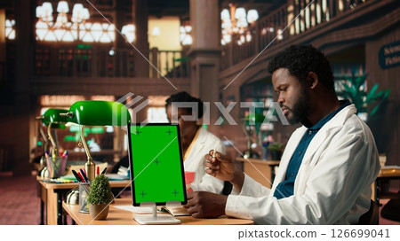 Medical student learns dentistry practices on a dummy jaw model next to mockup, developing dental qualifications through techniques. Study tools for exam preparations. Camera A. 126699041