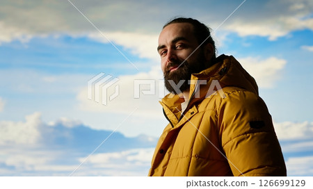Male explorer embraces the solitude of high altitude wilderness, climbing on top of the mountain for fresh air and a scenic background. Mindfulness and relaxation in the nature. Camera B. Male explorer embraces the solitude of high altitude wilderness, climbing on top of the mountain for fresh air and a scenic background. Mindfulness and relaxation in the nature. Camera B. 126699129