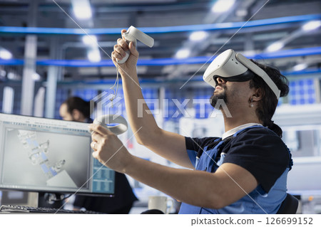 Photovoltaics factory professional using VR gear to do performance testing of solar panel designs. Staff member improving solar panel configurations for cost reduction using virtual reality technology Photovoltaics factory professional using VR gear to do performance testing of solar panel designs. Staff member improving solar panel configurations for cost reduction using virtual reality technology 126699152