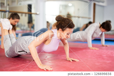 Group exercise in gym - women doing plank exercise 126699838