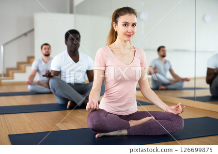 Woman sitting in lotus position with hands on knees folded in mudra 126699875
