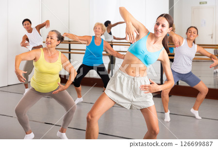 Group of dancers exercising modern dance movements in ball room Group of dancers exercising modern dance movements in ball room 126699887