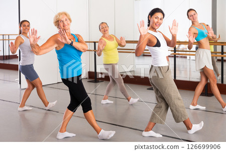 Women practicing vigorous dance movements in group dance class 126699906