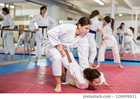 Women pupils train to perform defensive karate installations and attacking combat techniques Women pupils train to perform defensive karate installations and attacking combat techniques 126699911