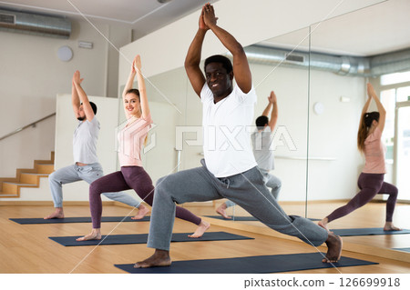 African american standing in Ashta Chandrasana with hands in prayer above head 126699918