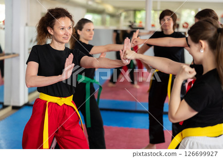 Women practice karate techniques in pairs 126699927