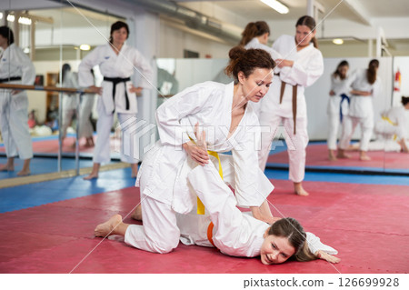 Women practice judo techniques in pairs 126699928