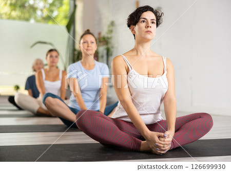Portrait of latin american woman making yoga meditation in lotus pose in fitness studio 126699930