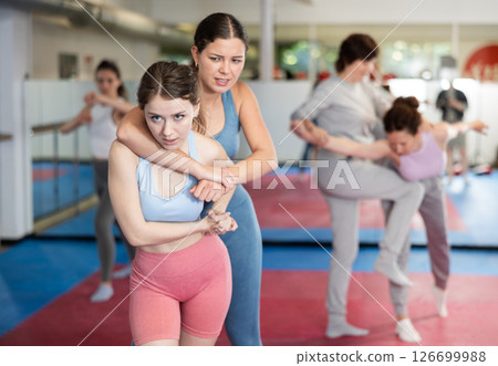 Women practice self-defense techniques in pairs 126699988