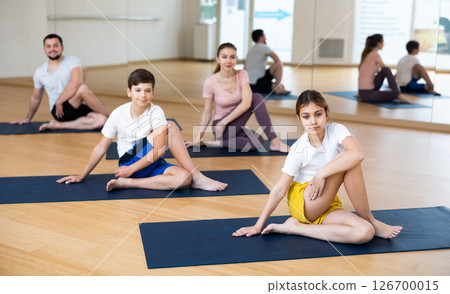 Family sitting in lord of the fishes pose during training 126700015