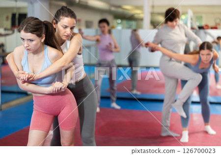 Women in pair perform effective impact on pain points while learning self-defense. Women in pair perform effective impact on pain points while learning self-defense. 126700023