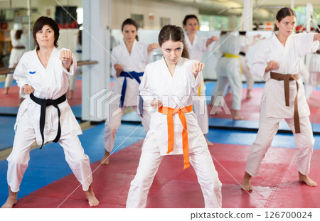 Group of women training karate techniques in studio Group of women training karate techniques in studio 126700024