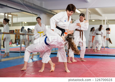 Women practicing a body punch in training 126700028