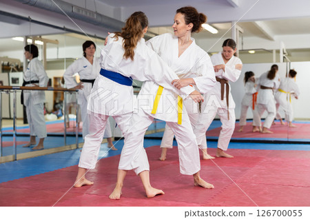 Women practice judo techniques in pairs Women practice judo techniques in pairs 126700055
