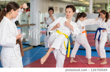 Women practice karate techniques in pairs 126700084
